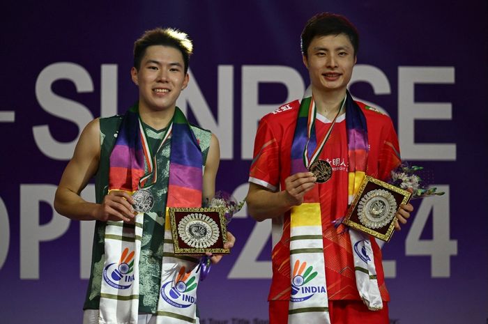 Tunggal putra China, Shi Yu Qi (kanan), berpose dengan piala setelah mengalahkan Lee Cheuk Yiu dari Hong Kong dalam final India Open 2024 yang diselenggarakan di K. D. Jadhav Indoor Hall, New Delhi, India, 21 Januari 2024.