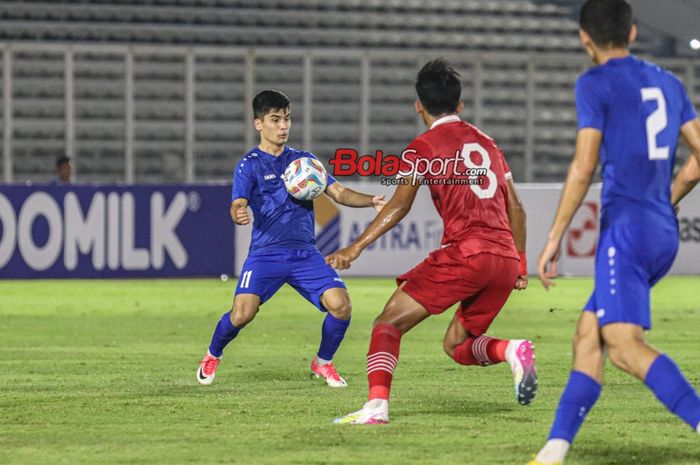 Komilov Murodjon (kiri) sedang menguasai bola dalam laga uji coba timnas U-20 Indonesia versus timnas U-20 Uzbekistan di Stadion Madya, Senayan, Jakarta, Selasa (30/1/2023) malam.