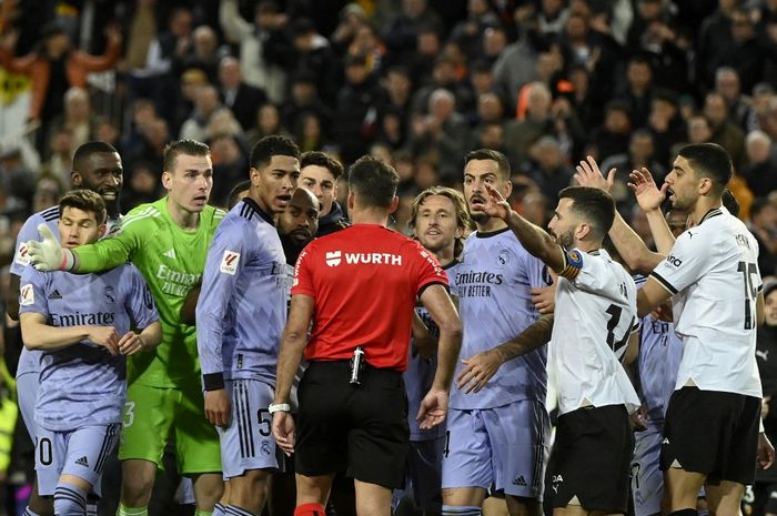 Wasit Gil Manzano beradu argumen dengan Jude Bellingham dan pemain lain Real Madrid dalam laga melawan Valencia pada lanjutan Liga Spanyol di Mestalla (2/3/2024).