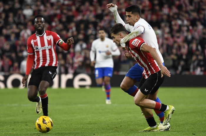 Bek Barcelona, Joao Cancelo, berduel dengan pemain Athletic Club pada laga pekan ke-27 Liga Spanyol di Stadion San Mames, Minggu (3/3/2024).