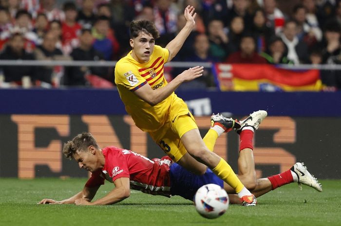 Pau Cubarsi (atas) berduel dengan Marcos Llorente dalam lawatan Barcelona ke markas Atletico Madrid di Metropolitano Stadium (17/3/2024).