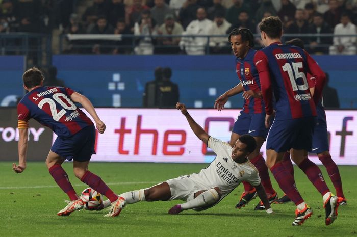 Penyerang Real Madrid, Rodrygo (bawah) dikepung para pemain Barcelona dalam duel El Clasico pada Piala Super Spanyol di Riyadh (14/1/2024). Salah satu skenario final Liga Champions musim ini bisa mempertemukan Barca vs Madrid.