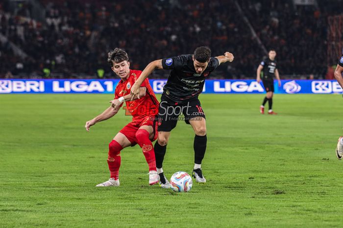 Ryo Matsumura (kiri) sedang merebut bola dengan Alexis Messidoro (kanan) dalam laga pekan ke-31 Liga 1 2023 antara Persija Jakarta versus Persis Solo di Stadion Utama Gelora Bung Karno, Senayan, Jakarta, Rabu (17/4/2024) malam.