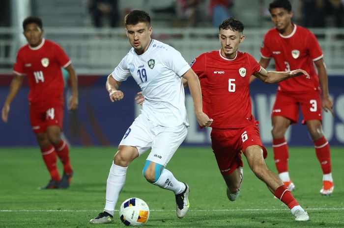 Ivar Jenner (kanan) mengawal Khusayin Norchaev dalam partai timnas U-23 Indonesia melawan Uzbekistan pada semifinal Piala Asia U-23 2024 di Doha (29/4/2024).