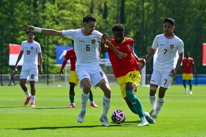 Ivar Jenner (kiri) berduel dengan Madiou Keita dalam laga play-off menuju Olimpiade 2024 antara timnas U-23 Indonesia vs Guinea di Clairefontaine, Prancis (9/5/2024).