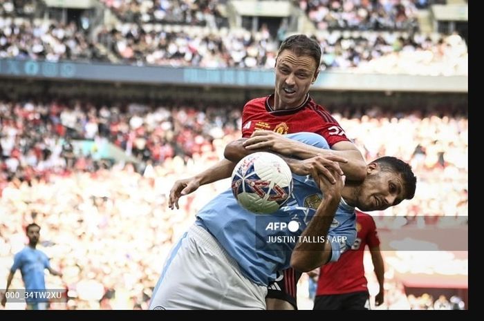 Rodri (depan) berduel dengan Jonny Evans dalam partai final Piala FA antara Man City vs Man United di Wembley (25/5/2024).