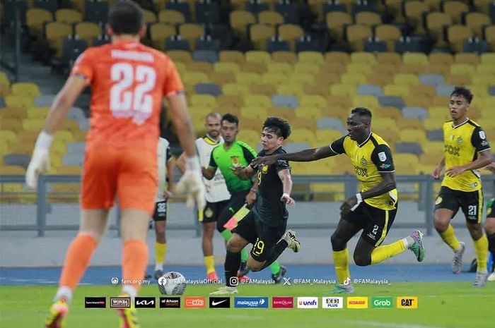 Winger Timnas Malaysia, Akhyar Rashid, mendapat pengawalan dari pemain Perak FC pada laga uji coba di Stadion Nasional Bukit Jalil, Jumat (31/5/2024) malam WIB.