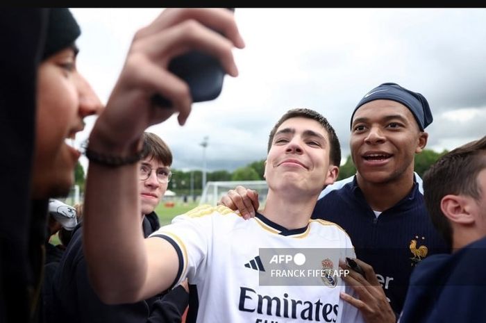 Kylian Mbappe berpose dengan fan Real Madrid pada momen latihan timnas Prancis di Clairefontaine (30/5/2024). Mbappe akan diresmikan sebagai pemain baru Los Blancos pekan-pekan ini.