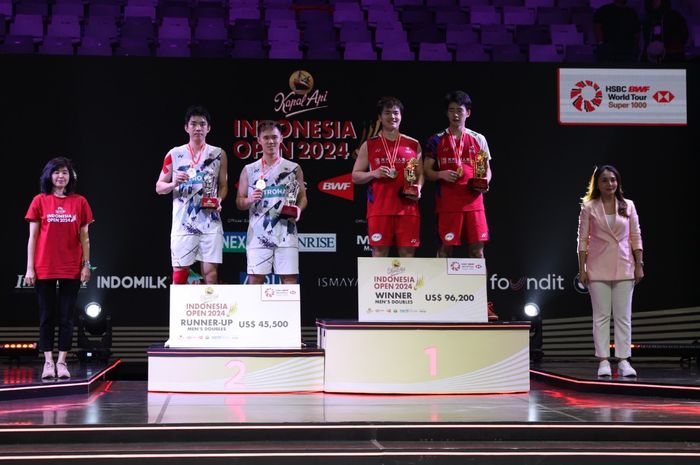 Man Wei Chong/Tee Kai Wun (Malaysia/jersey putih) dan Pasangan ganda putra China, Liang Wei Keng/Wang Chang, berpose di podium Indonesia Open 2024 di Istora Senayan, Jakarta, Minggu (9/6/2024).