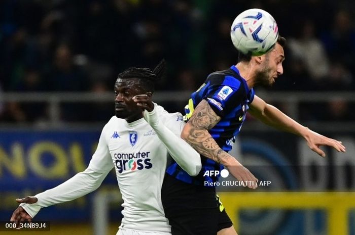 Penyerang Empoli, Mbaye Niang (kiri), berduel dengan gelandang Inter Milan, Hakan Calhanoglu, dalam laga Liga Italia pada 1 April 2024 di Stadion Giuseppe Meazza.