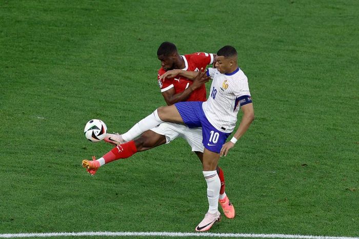 Penyerang Timnas Prancis, Kylian Mbappe (kanan), tengah berebut bola dengan penggawa Timnas Austria pada laga perdana Grup D Euro 2024.