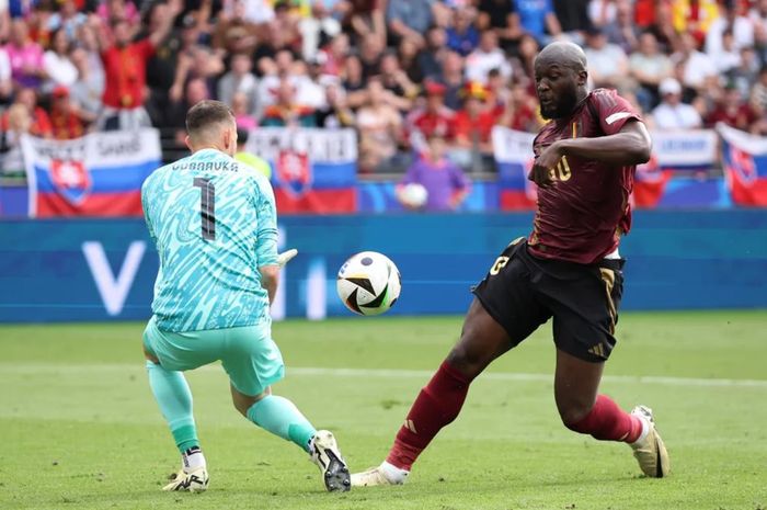 Penyerang Timnas Belgia, Romelu Lukaku (kanan), tengah berebut bola dengan kiper Timnas Slowakia, yakni Martin Dubravka (kiri).