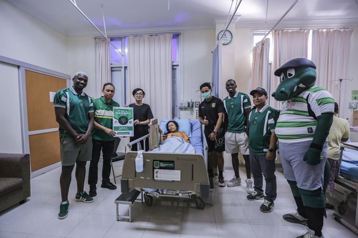 Direktur operasional Persebaya, Candra Wahyudi dan para pemain berfoto bersama dengan orang tua bayi beruntung yang melahirkan di Rumah Sakit Bhakti Dharma Husada.