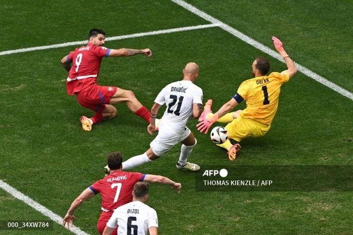 Kiper Slovenia, Jan Oblak (kuning), melakukan penyelamatan untuk peluang striker Serbia, Aleksandar Mitrovic, dalam laga Grup C EURO 2024, Kamis (20/6/2024) di Muenchen.