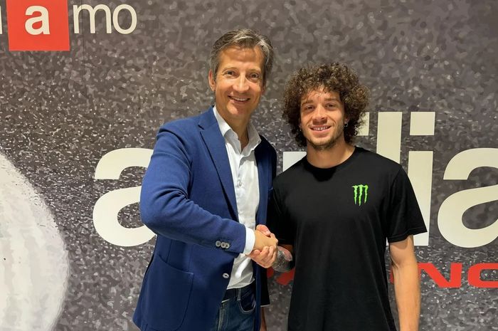 CEO Aprilia Racing, Massimo Rivola, berjabat tangan dengan Marco Bezzecchi. Bezzecchi akan menjadi pembalap Aprilia di MotoGP pada 2025 dan selanjutnya.