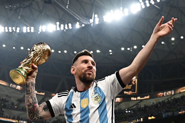 Lionel Messi berpose dengan trofi juara Piala Dunia 2022 untuk timnas Argentina.