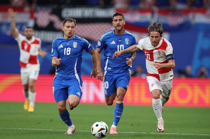 Luka Modric (kanan) beradu lari dengan Nicolo Barella (18) dalam duel timnas Kroasia vs timnas Italia pada laga Grup B Euro 2024 di Leipzig (24/6/2024).