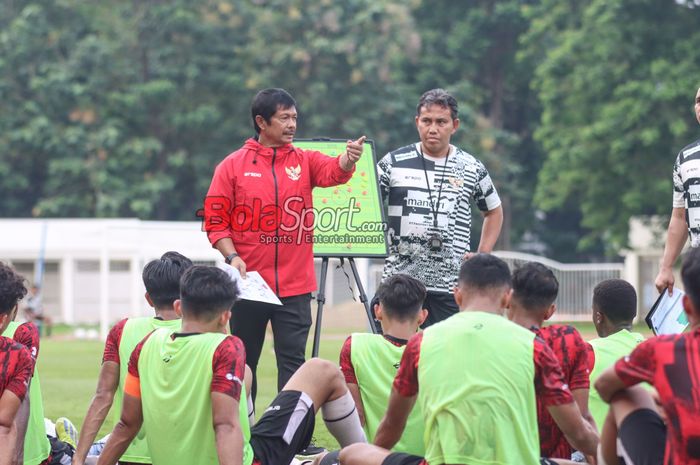 Pelatih timnas U-19 Indonesia, Indra Sjafri (kiri) dan asistennya bernama Bima Sakti (kanan) sedang memantau para pemainnya berlatih di Stadion Madya, Senayan, Jakarta, Senin (1/7/2024).