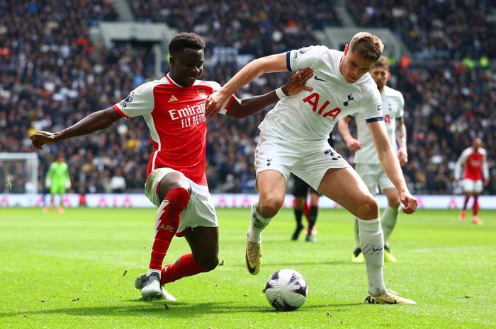 Bek Tottenham Micky van de Ven (kanan) tengah berebut bola dengan winger Arsenal Bukayo Saka.