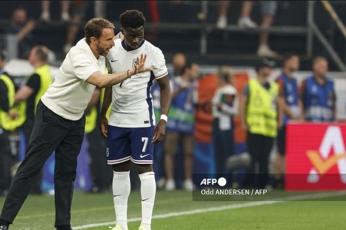 Pelatih timnas Inggris, Gareth Southgate, berbicara dengan Bukayo Saka dalam duel semifinal Euro 2024 melawan Belanda (10/7/2024).