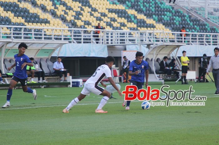 Pemain Kamboja U-19 Som Borith sedang menguasai bola di bayang-bayangi oleh pemain Timor leste U-19 Ricardo Rorinha Dos Santos Bianco di stadion Gelora Bung Tomo, Surabaya, Rabu (17/7/2024) sore.