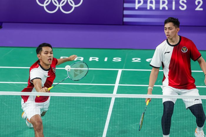 Ganda putra Indonesia, Fajar Alfian, mengembalikan kok di samping Muhammad Rian Ardianto dalam pertandingan babak penyisihan Grup C Olimpiade Paris 2024 di Paris, Prancis, 27 Juli 2024.