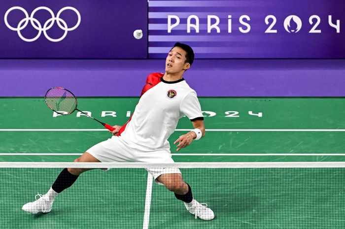 Tunggal putra Indonesia, Jonatan Christie, bereaksi saat melakukan pukulan ke arah Julien Carraggi dari Belgia dalam pertandingan penyisihan Grup L Olimpiade Paris 2024 di Paris, Prancis, 27 Juli 2024. 