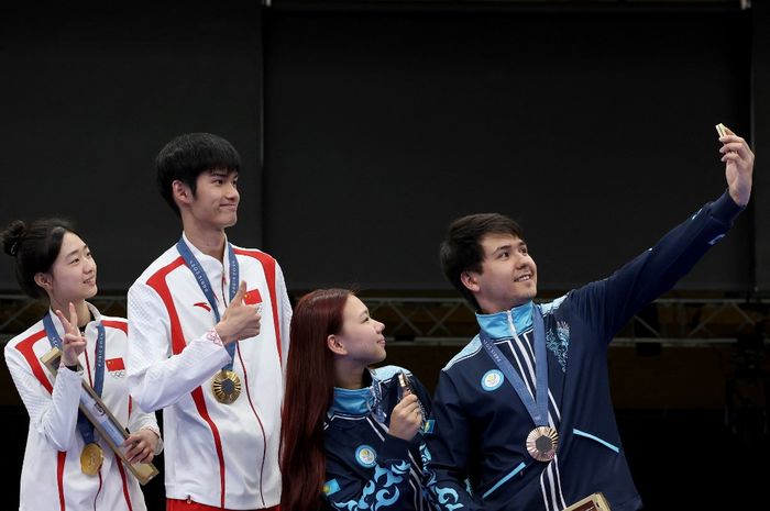 Peraih medali emas dari China, Yuting Huang dan Lihao Sheng (Kiri), serta peraih medali perunggu dari Kazakhstan, Alexandra Le dan Islam Satpayev (Kanan) berswafoto di atas podium selama upacara penyerahan medali nomor beregu campuran senapan angin 10 meter Olimpiade Paris 2024 di Chateauroux Shooting Centre, Prancis, 27 Juli 2024.