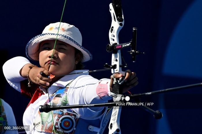 Pemanah putri Indonesia, Rezza Octavia, melepaskan anak panah saat menghadapi Malaysia pada babak 16 besar beregu putri recurve, Minggu, 28 Juli 2024