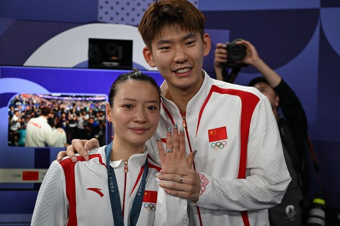 Pebulu tangkis ganda campuran China, Huang Ya Qiong, berpose dengan cincin di jari usai dilamar pemain ganda putra, Liu Yu Chen, seusai memastikan medali emas ganda campuran di Porte de la Chapelle Arena, Jumat (2/8/2024).