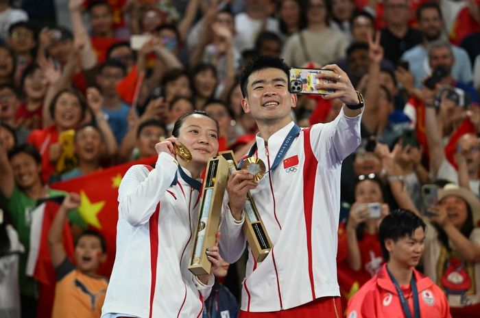 Pasangan ganda campuran China, Zheng Si Wei/Huang Ya Qiong, berpose dengan medali emas Olimpiade Paris 2024 di Porte de la Chapelle Arena, Jumat (2/8/2024).