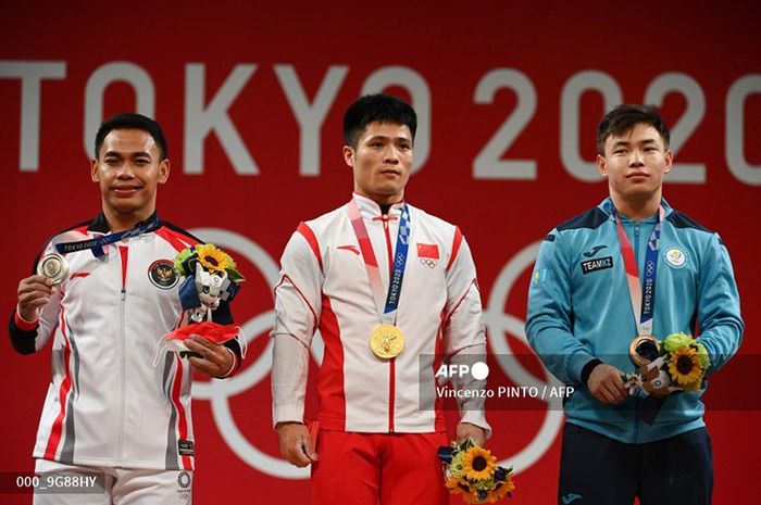 (Ki-Ka) Peraih medali perak Eko Yuli Irawan dari Indonesia, peraih medali emas Li Fabin dari China dan peraih medali perunggu Igor Son dari Kazakhstan berdiri di podium untuk upacara penyerahan medali kompetisi angkat besi nomor 61kg putra selama Olimpiade Tokyo 2020 di Tokyo International Forum, Tokyo, 25 Juli 2021. 