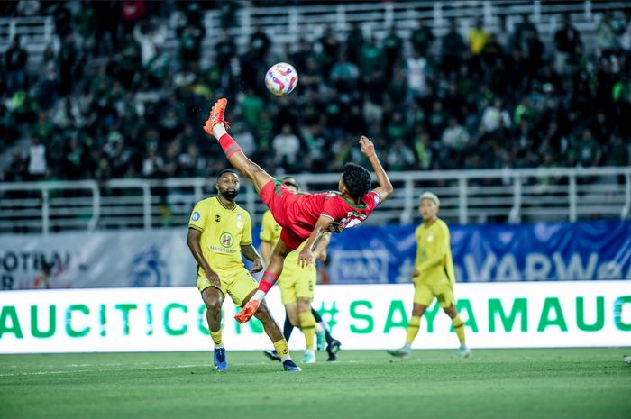 Pemain Persebaya Surabaya, Alfan Suaib, melakukan tendangan salto saat melawan Barito Putera, Jumat (23/8/2024).