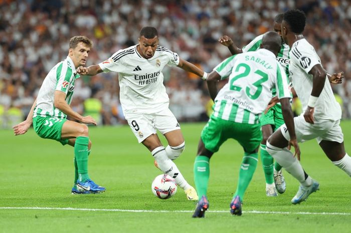 Aksi penyerang Real Madrid, Kylian Mbappe, saat diadang oleh para pemain Real Betis dalam jornada 4 Liga Spanyol 2024-2025 di Stadion Santiago Bernabeu, Minggu (1/9/2024).