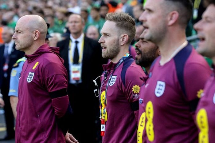 Pelatih interim Timnas Inggris, Lee Carsley (kiri), hanya mendengarkan tetapi tidak ikut menyanyikan lagu kebangsaan dalam laga UEFA Nations League melawan Irlandia, Sabtu (7/9/2024) di Dublin.