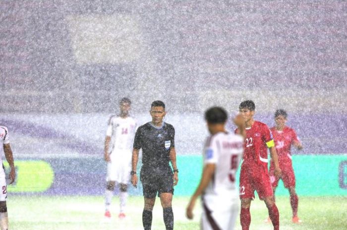 Duel Timnas Qatar versus Timnas Korea Utara diwarnai hujan deras yang menimbulkan genangan air di lapangan.