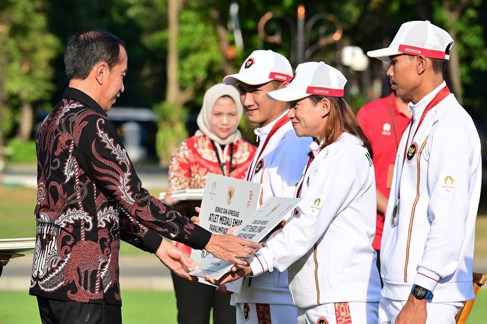 Presiden RI, Joko Widodo (kiri), secara simbolis memberi bonus kepada atlet Indonesia Paralimpiade Paris 2024 di Istana Merdeka, Jakarta, 11 September 2024. Tampak dalam gambar: atlet para bulu tangkis Hikmat Ramdani dan Leani Ratri Oktila, serta atlet para atletik Saptoyogo Purnomo. 