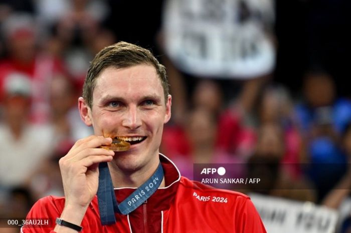 Tunggal putra Denmark, Viktor Axelsen, menggigit keping medali emas Olimpiade Paris 2024 di Porte de La Chapelle Arena, Paris, Prancis, 5 Agustus 2024