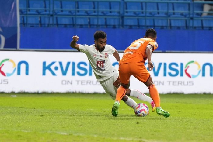 Bek sayap Malut United FC, Yance Sayuri (putih), berusaha melewati pemain Borneo FC, Leo Guntara, dalam laga Liga 1, Selasa (17/9/2024) di Stadion Batakan, Balikpapan.