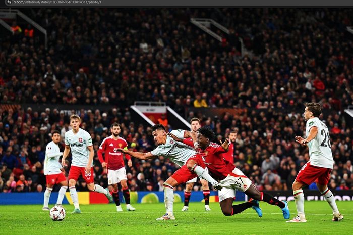 Aksi bek FC Twente berdarah Indonesia, Mees Hilgers, menjatuhkan Kobbie Mainoo dalam laga melawan Manchester United pada matchday 1 Liga Europa 2024-2025 di Stadion Old Trafford, Rabu (25/9/2024).