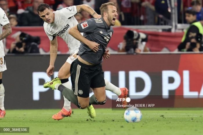 Striker Bayern Muenchen, Harry Kane, dihentikan oleh gelandang Bayer Leverkusen, Granit Xhaka, dalam laga pekan ke-5 Bundesliga, Sabtu (28/9/2024) di Allianz Arena.