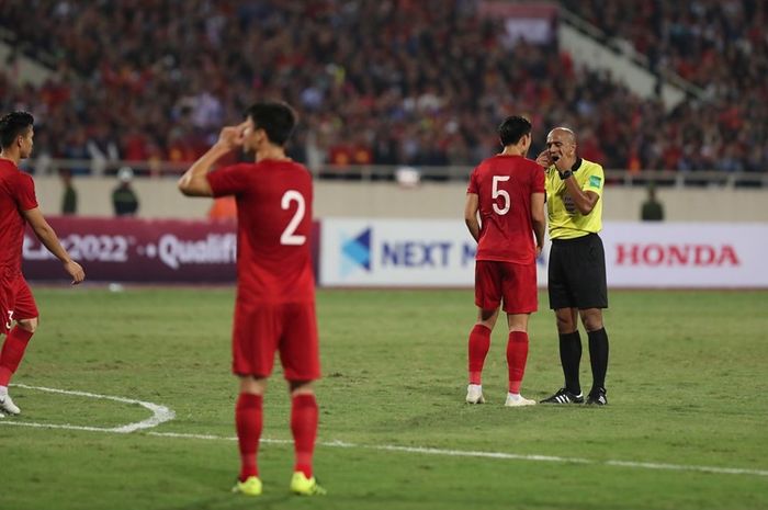 Wasit asal Oman, Ahmed Al Kaf, memberikan penjelasan kepada bek Vietnam Doan Van Hau dalam laga Kualifikasi Piala Dunia 2022 melawan Thailand.