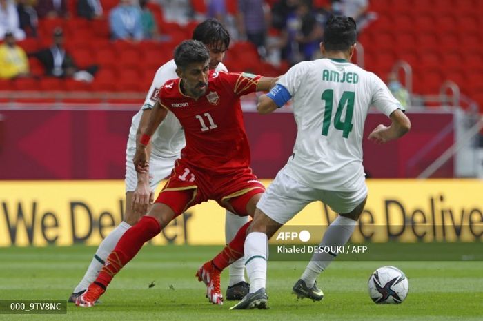 Penyerang Bahrain Ismail Abdullatif (tengah) dan gelandang Irak Amjed Attwan (kanan) berebut bola selama pertandingan sepak bola grup A Piala Arab FIFA 2021 antara Bahrain dan Irak di Stadion Al-Thumama di ibu kota Doha pada 3 Desember 2021