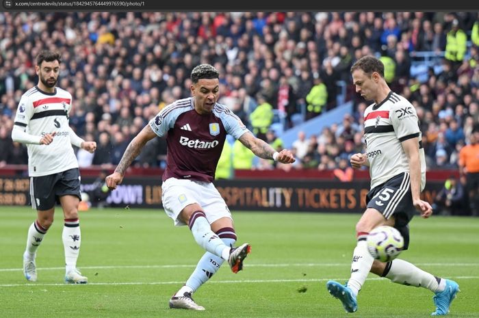 Momen bek uzur milik Manchester United, Jonny Evans, melakukan blok dari tendangan pemain Aston Villa.