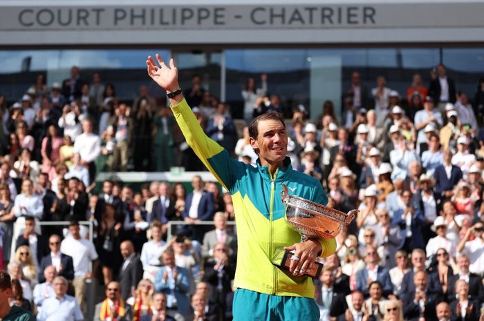 Rafael Nadal melambaikan tangan sambil memegang Piala The Musketeers saat merayakan kemenangan atas Casper Ruud dalam final tunggal putra Roland-Garros Open di Court Philippe-Chatrier, Paris, 5 Juni 2022.