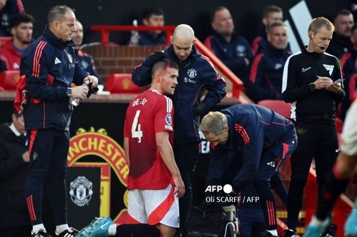 Bek Manchester United, Matthijs de Ligt, mendapatkan perawatan di tepi lapangan saat kepalanya bocor dalam laga melawan Brentford di Old Trafford, Sabtu (19/10/2024) malam WIB.