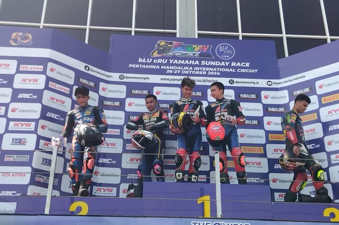 Aldi Satya Mahendra (tengah), Candra (kiri), Wahyu Nugroho (kanan) di podium usai melakoni sesi race 2 R25 Pro Yamaha Sunday Race 2024 di Sirkuit Mandalika, Minggu (27/10/2024)