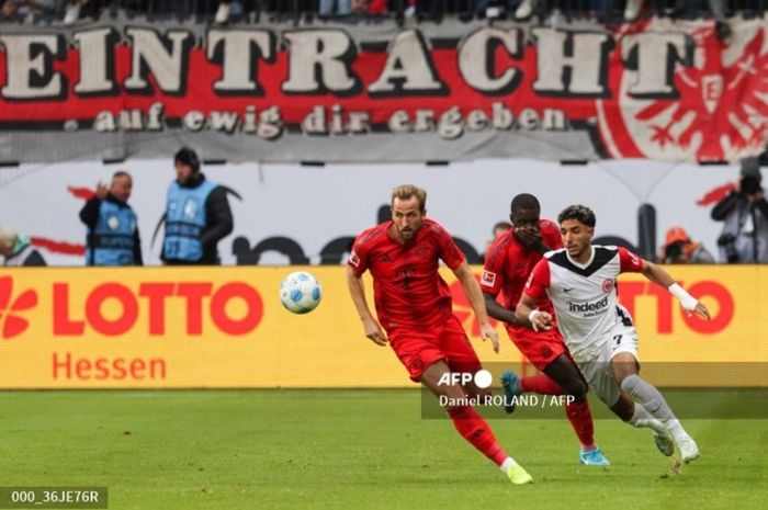 Striker Bayern Muenchen, Harry Kane (kiri), mengejar bola dengan penyerang Eintracht Frankfurt, Omar Marmoush, dalam laga Bundesliga pada 6 Oktober 2024 di Frankfurt.