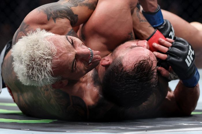 Charles Oliveira menjulurkan lidah saat mengendalikan Michael Chandler dalam grappling pada pertarungan kelas ringan dalam ajang UFC 309 di Madison Square Garden, New York, Amerika Serikat, 16 November 2024.