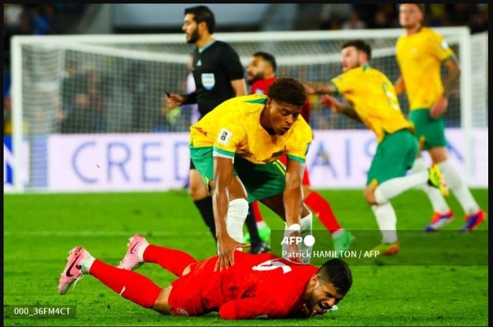 Pemain timnas Australia, Kusini Yengi (atas) membangunkan pemain Bahrain, Sayed Baqer, dalam duel Kualifikasi Piala Dunia 2024. Australia diwanti-wanti agar tidak terjebak permainan akting guling-guling dan gol menit akhir dari pemain Bahrain seperti saat menghadapi timnas Indonesia.